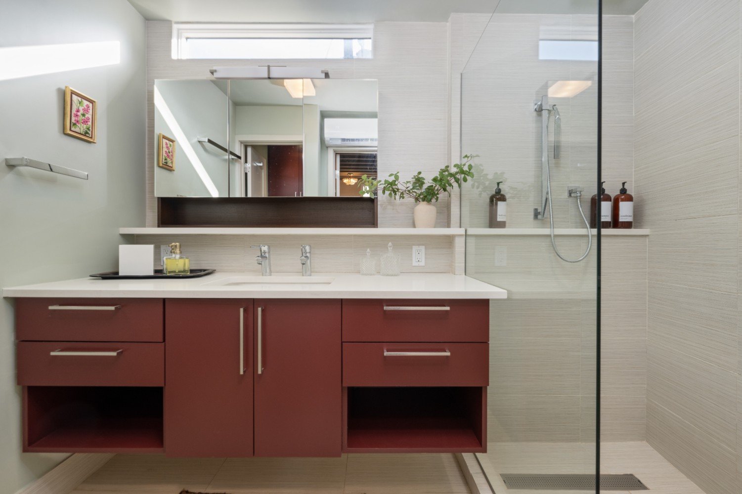 a bathroom with a red vanity and a glass-enclosed shower