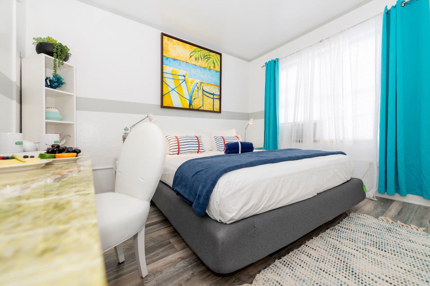 A hotel room with a bed, desk, and window