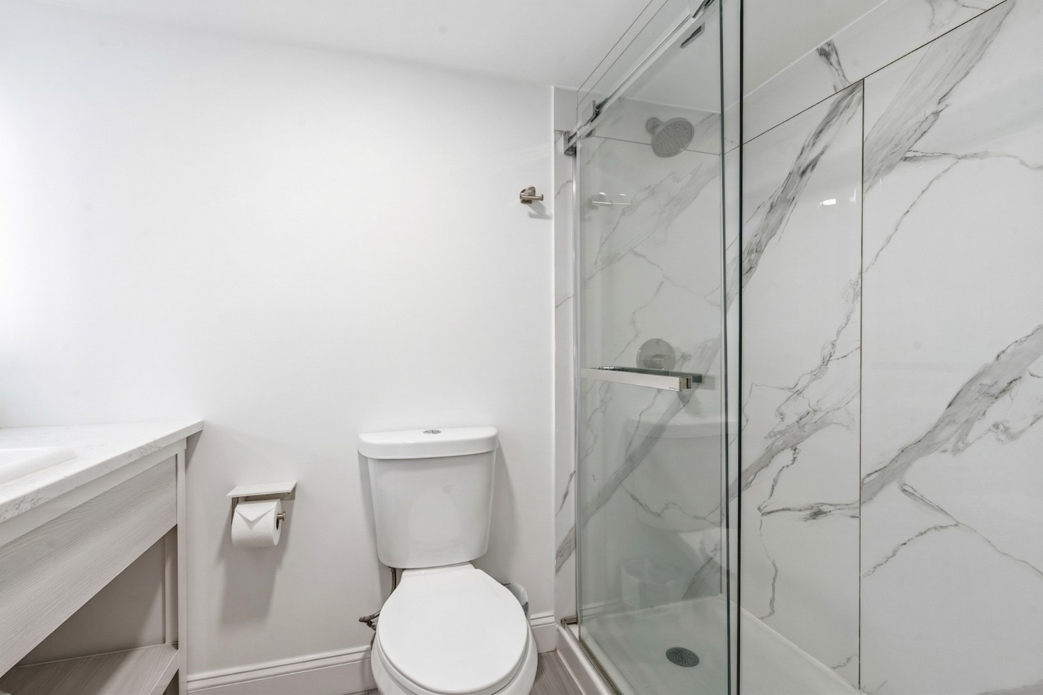 A bathroom with a toilet, shower, and sink