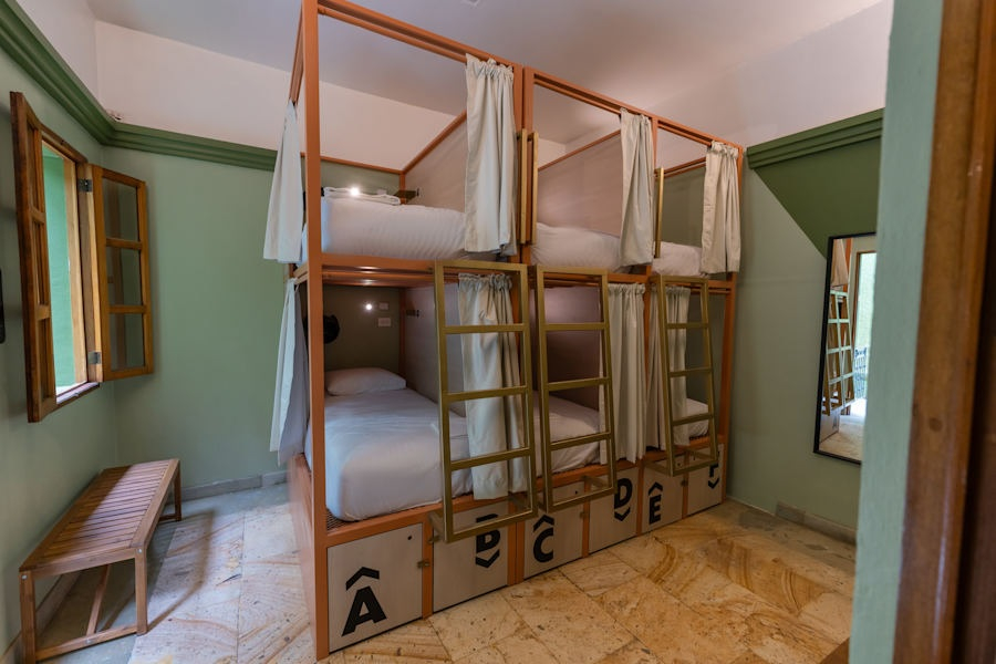 A room with a bunkbed and a bench