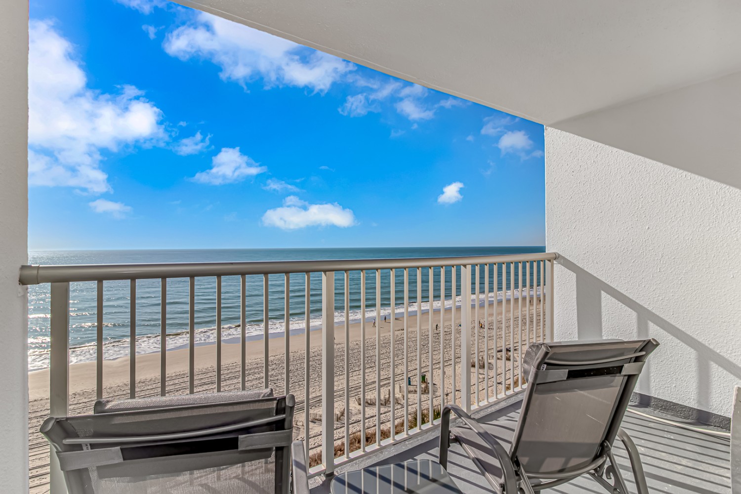 A balcony with a view of the beach and ocean